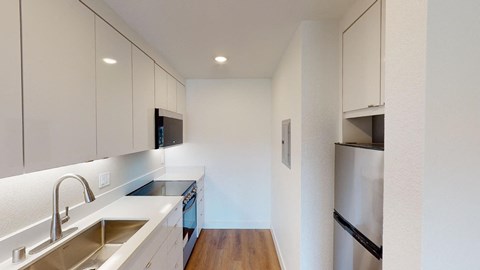 a kitchen with white cabinets and stainless steel appliances
