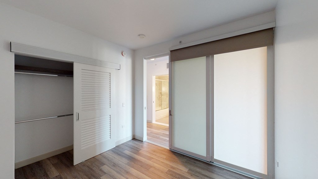 a bedroom with two closets and a hardwood floor