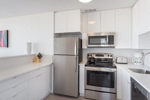a kitchen with white cabinets and stainless steel appliances