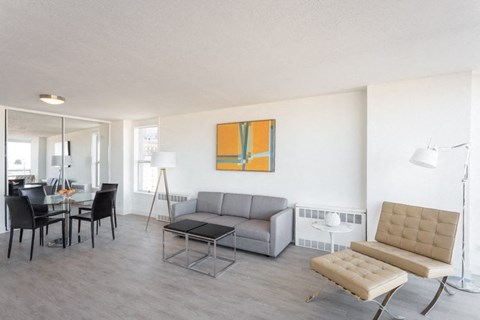 a living room with a gray couch and a yellow painting on the wall