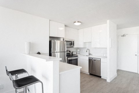 a kitchen with white cabinets and stainless steel appliances