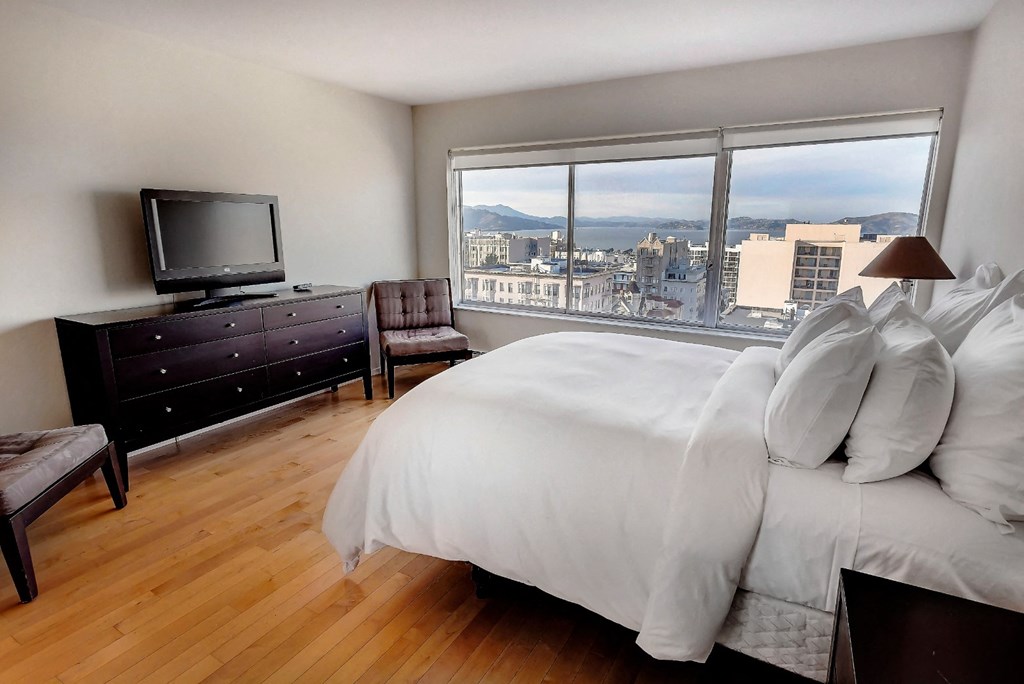 a bedroom with a large window and a large bed