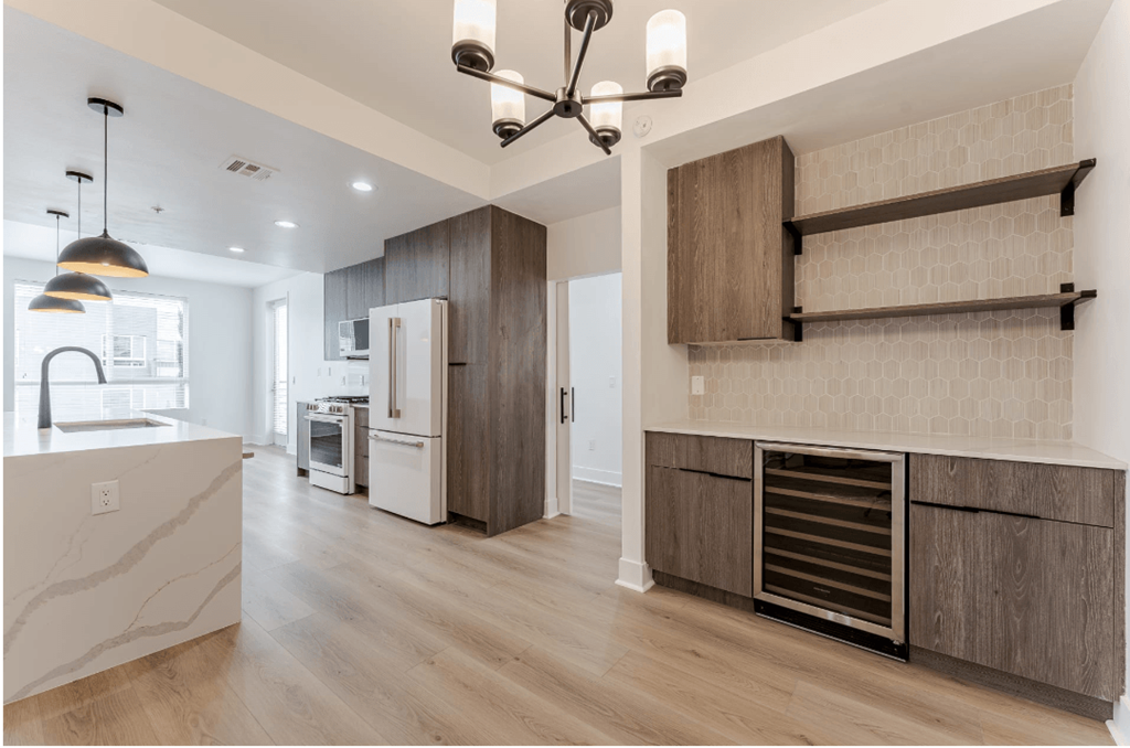 A modern kitchen with a refrigerator, oven, and a countertop.
