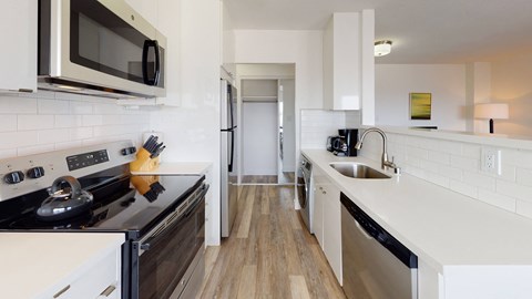 a kitchen with a stove and a sink and a microwave