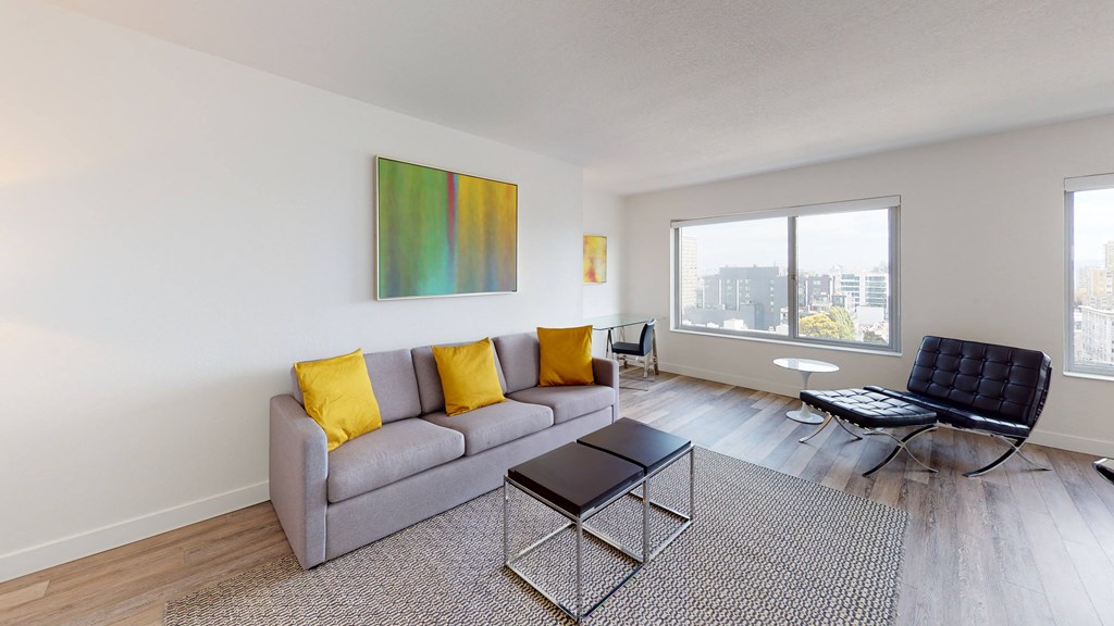 a living room with a gray couch and yellow pillows