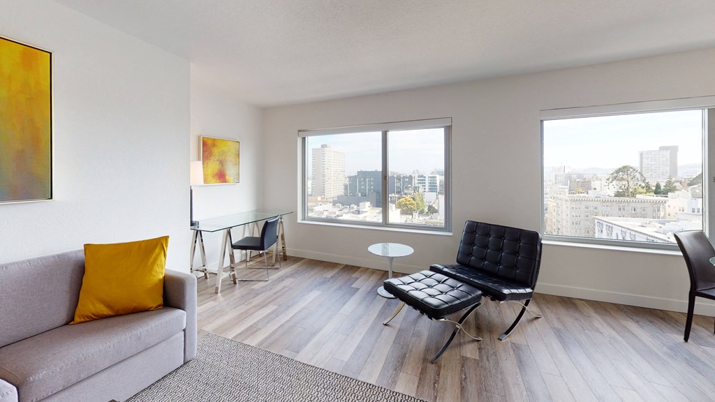 a living room with a couch chair and table with a view of the city