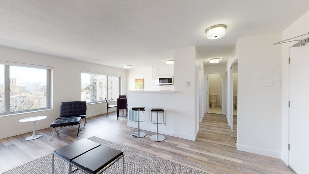 a living room with white walls and hardwood floors