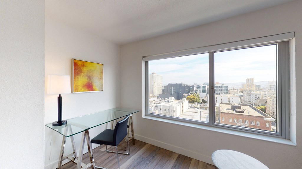 a room with a large window and a glass desk with a chair