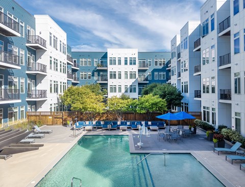 A swimming pool in the middle of a courtyard surrounded by buildings.