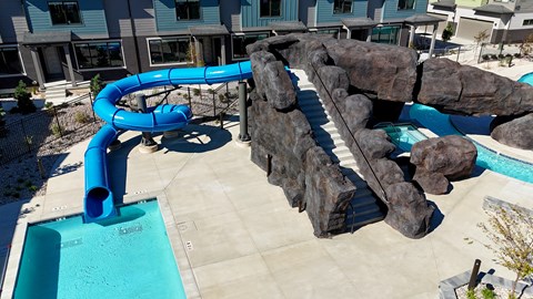 Blue water slide in a pool at H2O Townhomes, Utah, 84119