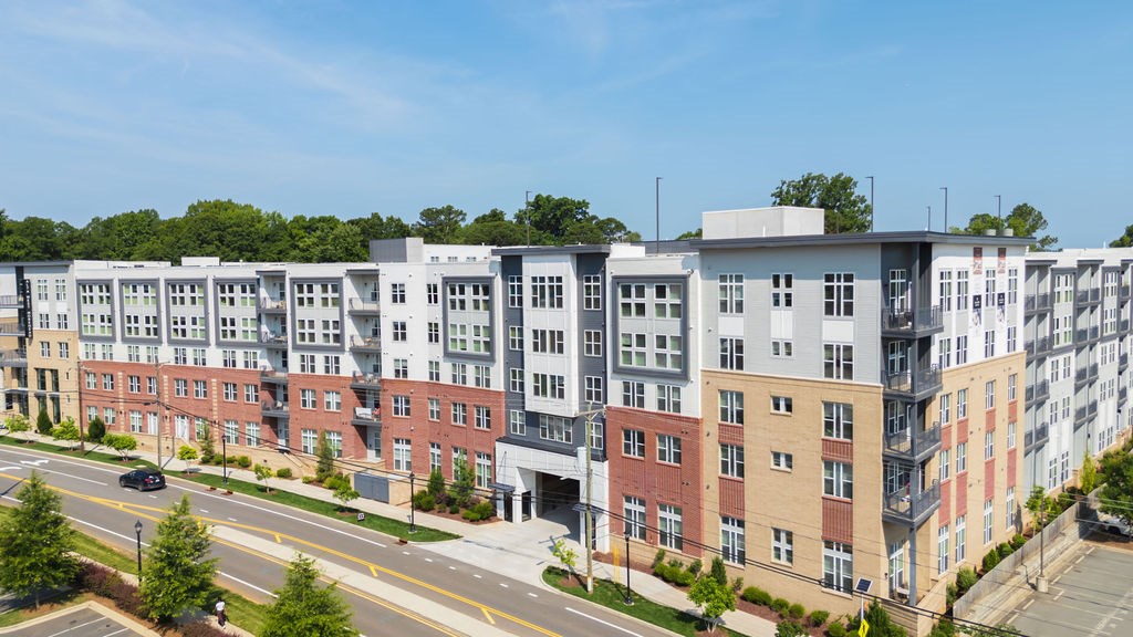 A row of modern apartment buildings with trees in the background.