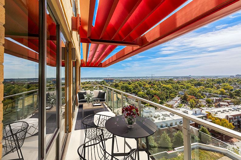 a balcony with a table and chairs overlooking a city