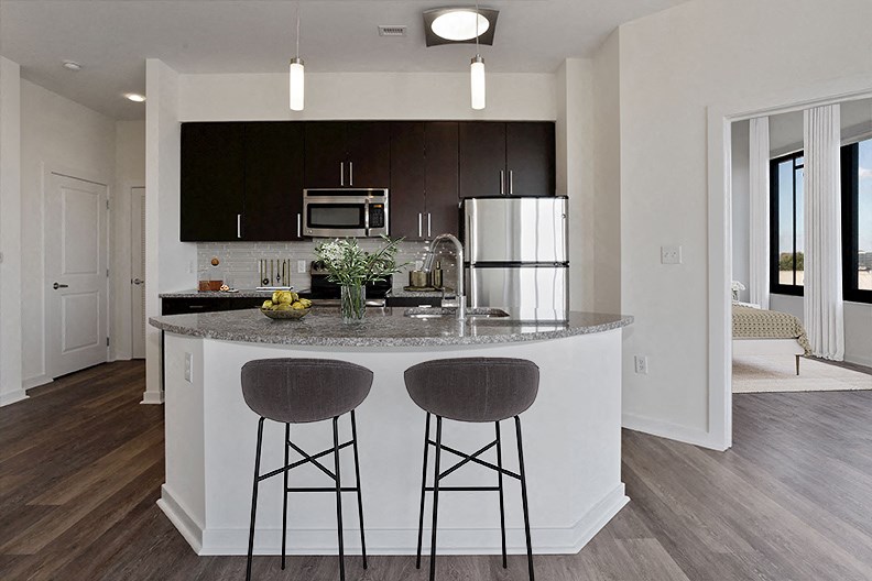 a kitchen with a large island with two bar stools