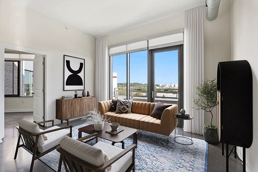 a living room with a couch and a tv in front of a window