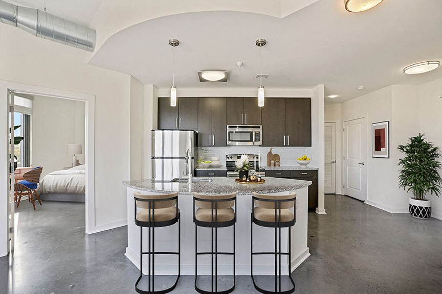 an open kitchen with a island with three stools