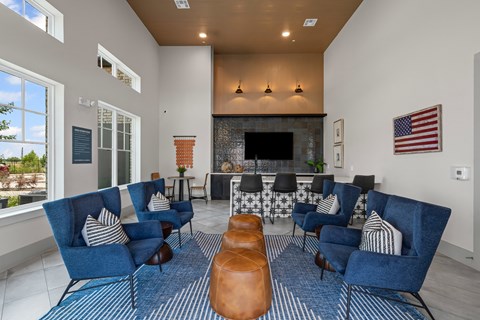 A living room with blue chairs and a fireplace.