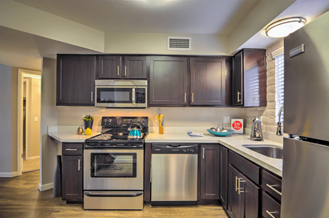 A kitchen with dark brown cabinets and stainless steel appliances.