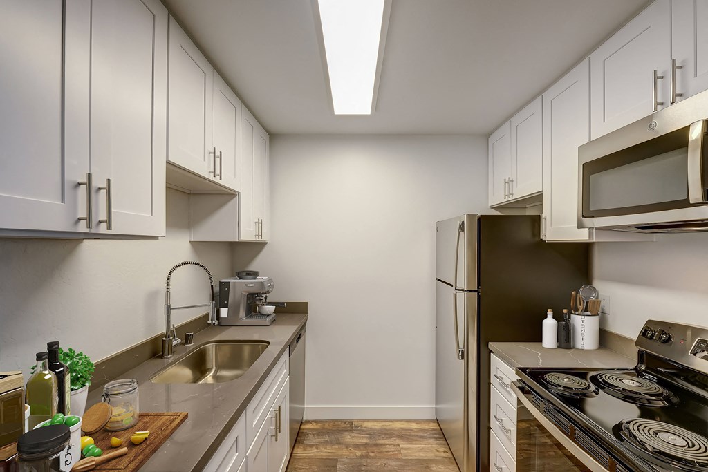 a kitchen with white cabinets and a stainless steel refrigerator