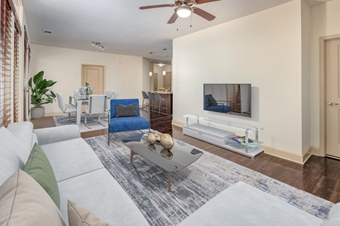 A living room with a white couch and a grey coffee table.