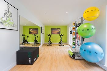 A room with exercise equipment and a green wall.