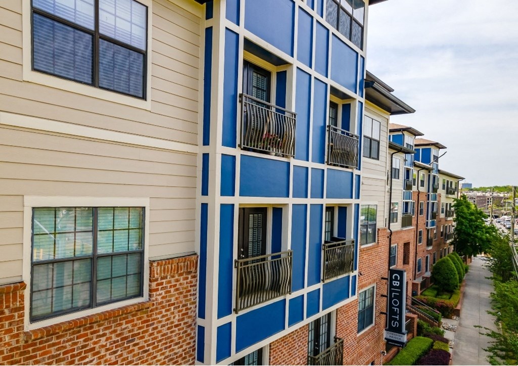 a view of a building with balconies and a sidewalk