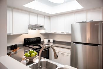 A modern kitchen with a stainless steel refrigerator and a skylight above the counter.