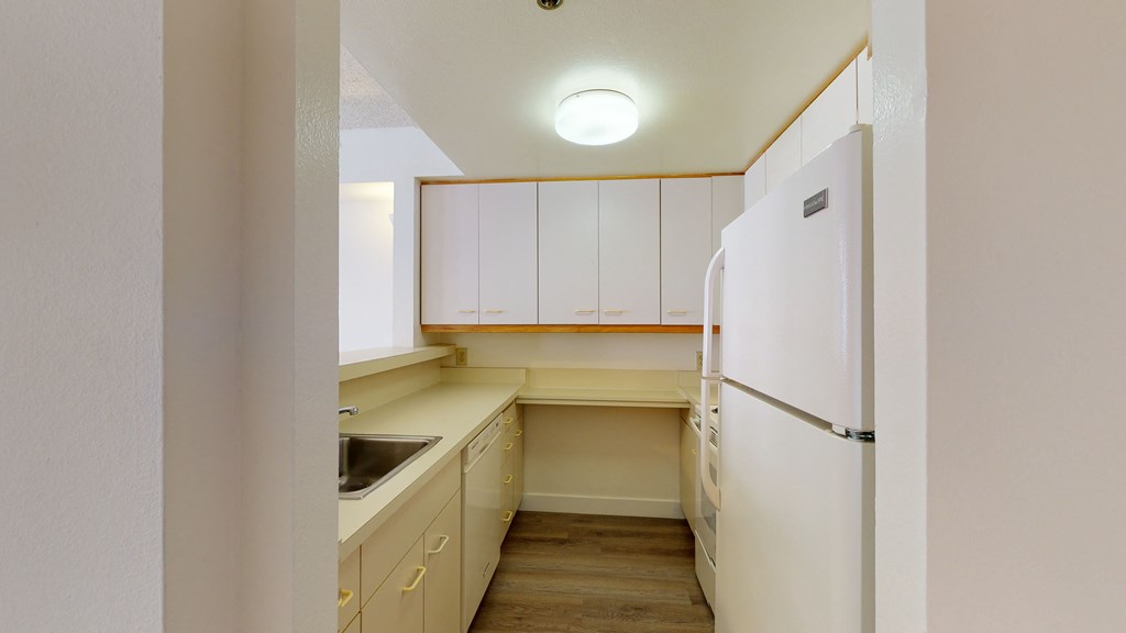 a kitchen with white cabinets and a white refrigerator