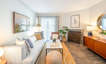 A living room with a white couch, a coffee table, and a fireplace.