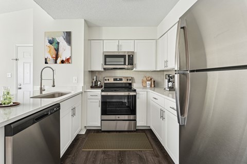 A modern kitchen with stainless steel appliances and white cabinets.