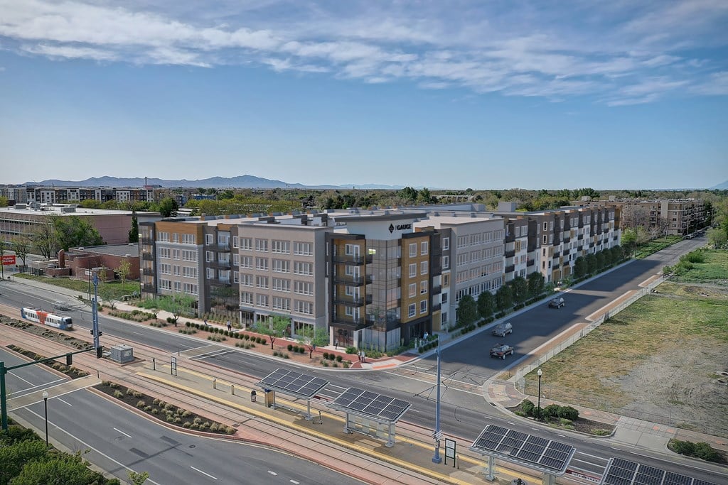 A city street with cars and buildings on either side.