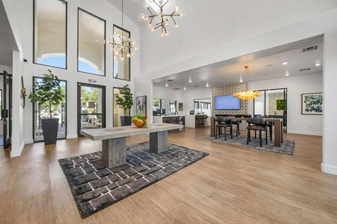 A modern living room with a large wooden table and a chandelier.