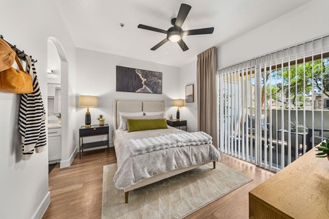 A bedroom with a large bed and a ceiling fan.