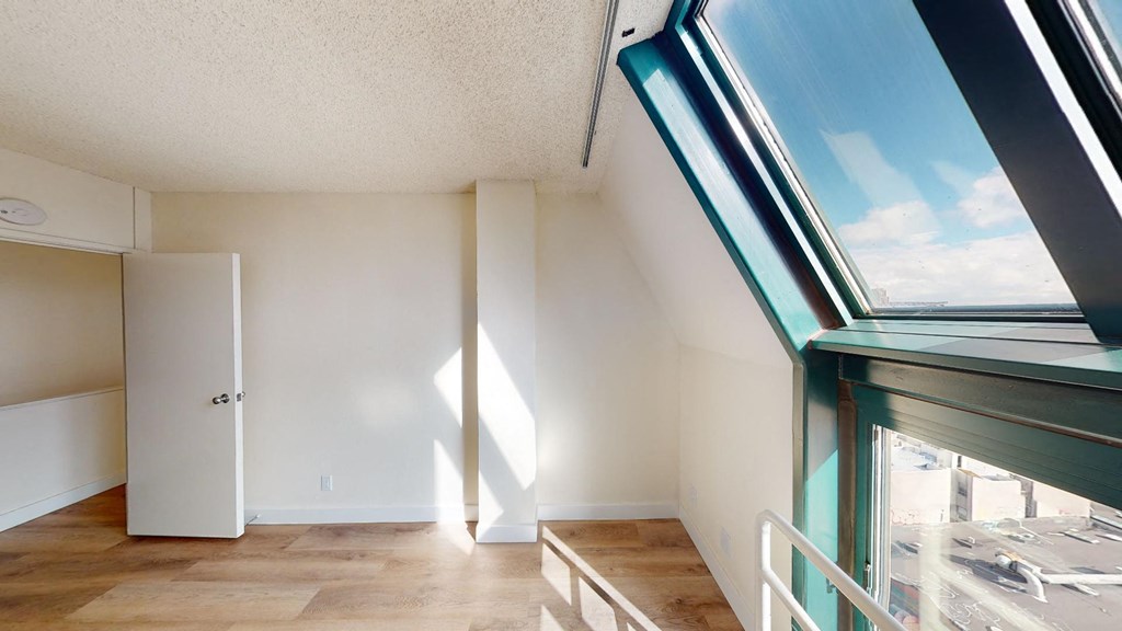 a living room with a large window and wooden floors