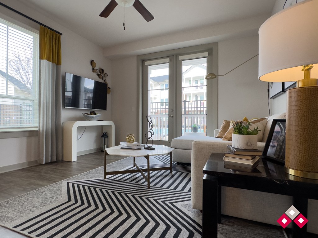 a living room with a rug and a couch and a tv