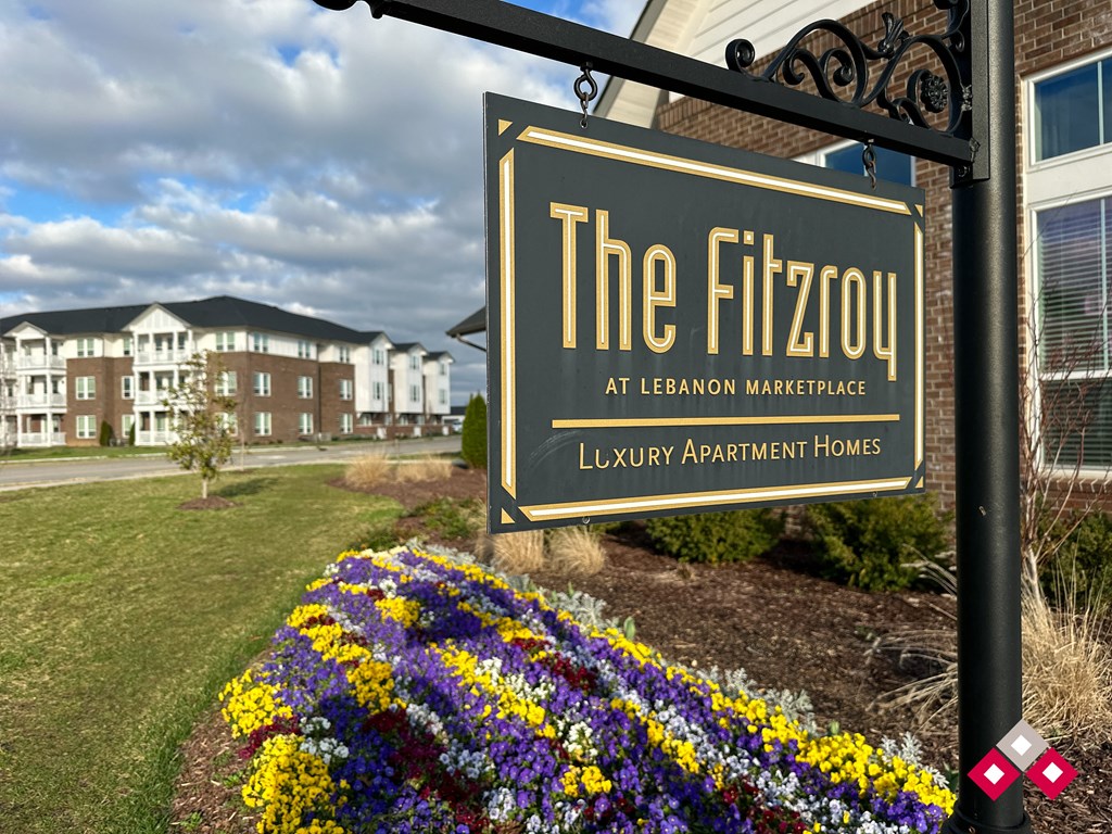 a sign for the flixtown marketplace in front of flowers