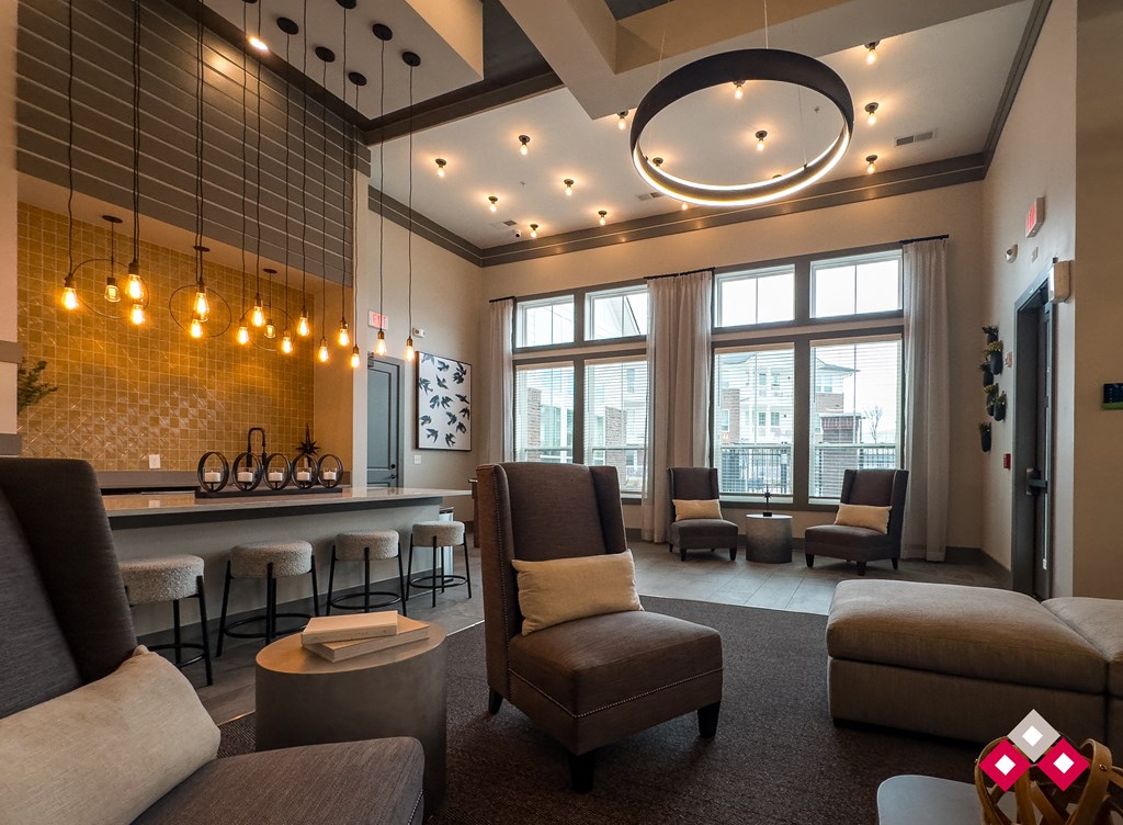 a lounge area with couches chairs and a bar and large windows