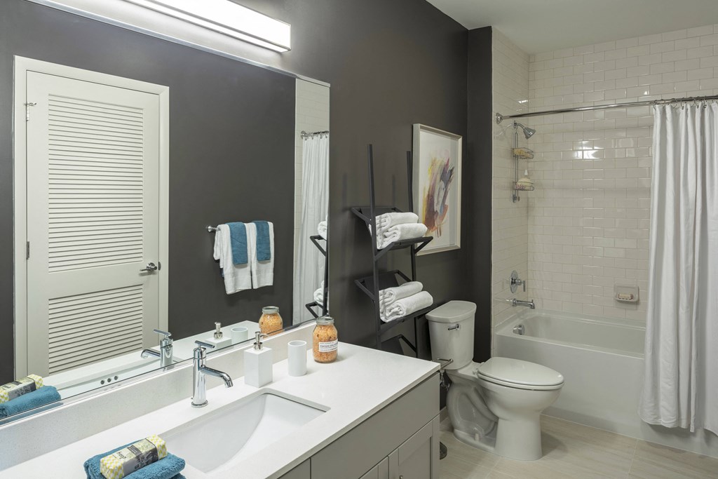 a bathroom with a white sink and toilet next to a white bathtub