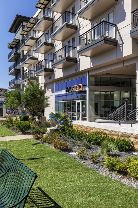 A green bench is in front of a building with a blue sign.