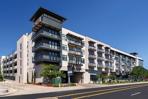 A modern multi-story building with a clear blue sky in the background.