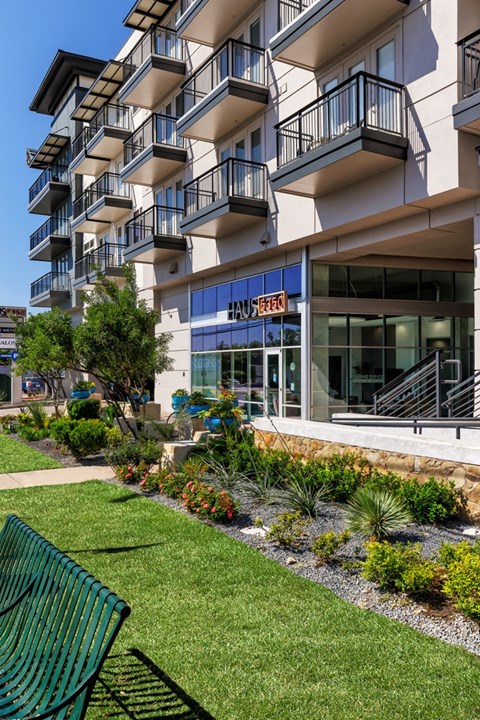 A green bench is in front of a building with a blue sign.