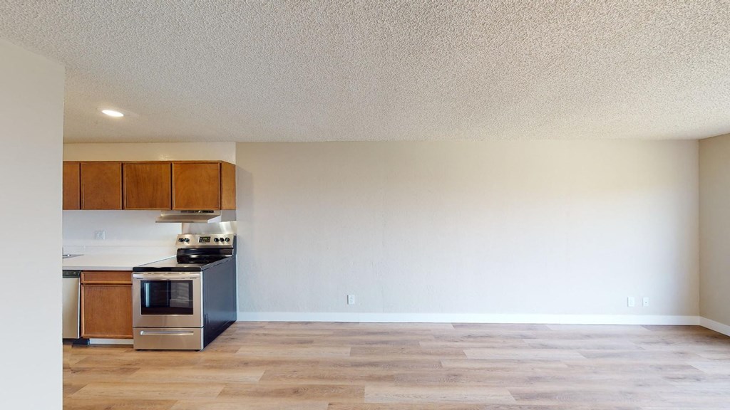 a kitchen and living room with wood floors and white walls