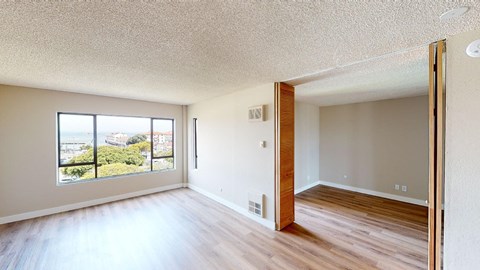 a bedroom with hardwood floors and a large window