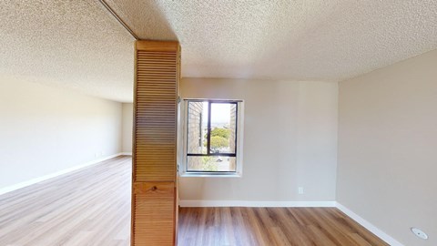 a bedroom with hardwood floors and white walls