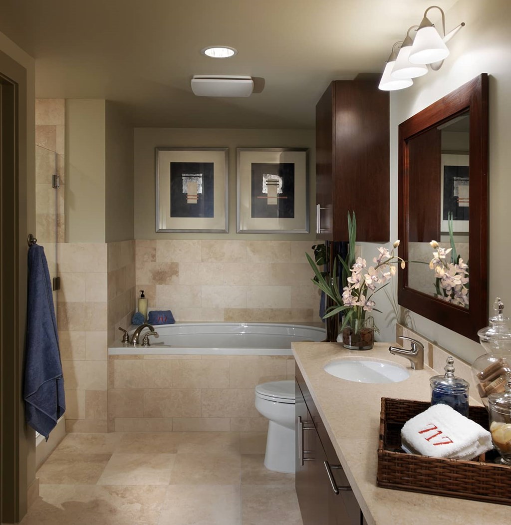 A bathroom with a toilet, sink, and mirror.