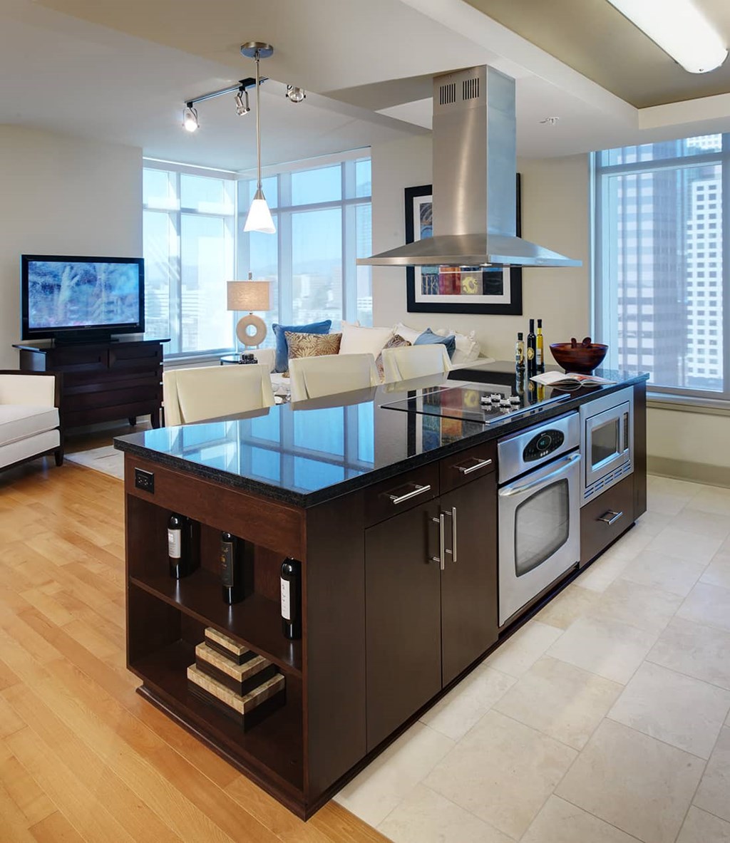 A modern kitchen with a dark wood island and stainless steel appliances.