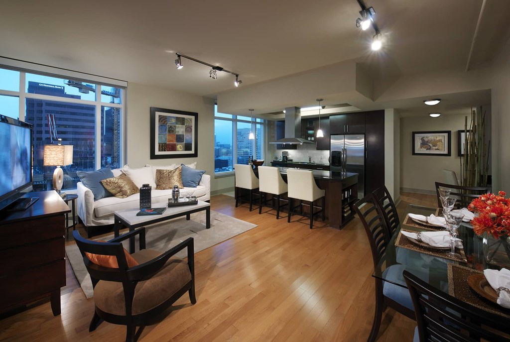 A modern living room with a dining area in the background.