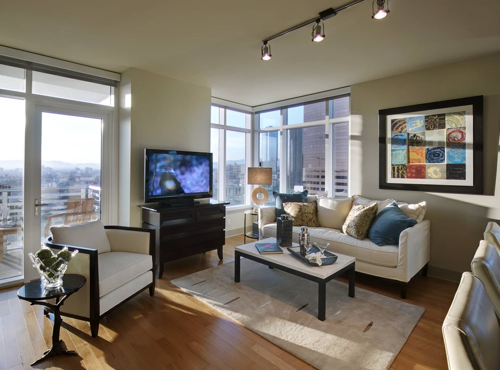 A living room with a white couch, a coffee table, and a television.