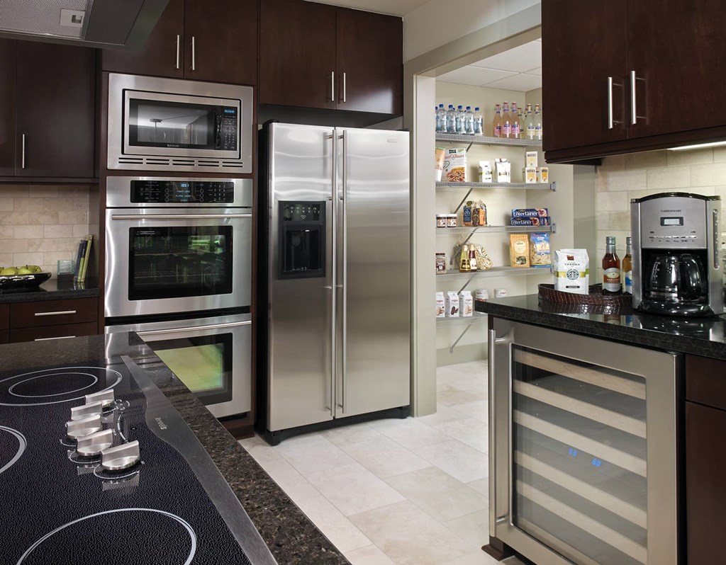 A modern kitchen with a stainless steel refrigerator and oven.