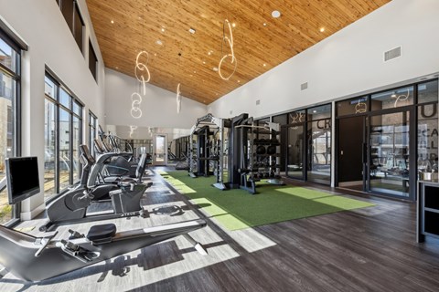 A gym with a variety of equipment including treadmills, weights, and exercise machines.