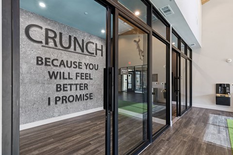A glass door with a sign that says "CRUNCH" on it.